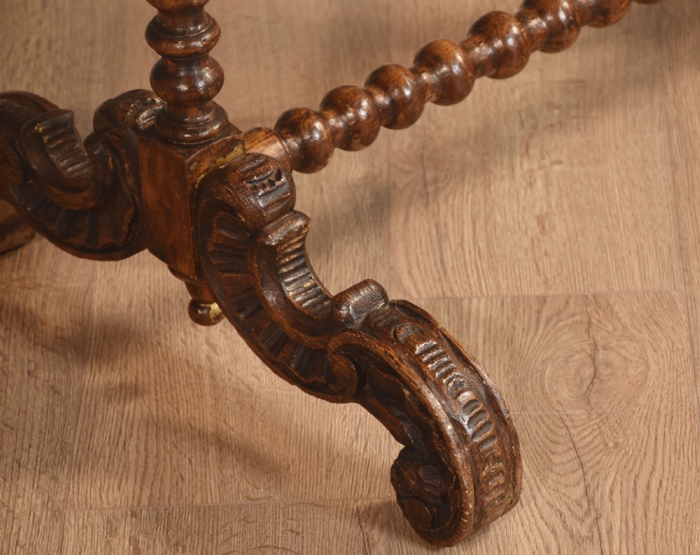 A free-standing carved dark oak dinner gong featuring barley twist columns, intricate scroll cresting, a suspended circular brass disc, and a leather striker. View V