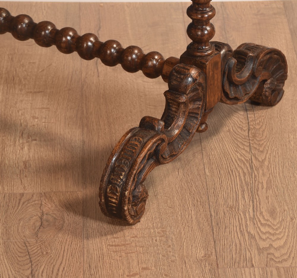 A free-standing carved dark oak dinner gong featuring barley twist columns, intricate scroll cresting, a suspended circular brass disc, and a leather striker. View IX