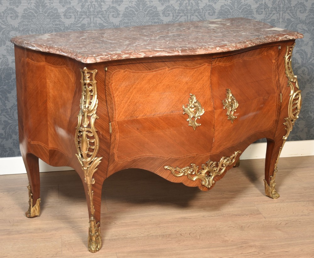 A late 18th-century French kingwood bombe commode featuring ornate gilt bronze mounts, cabriole legs, and a shaped marble top. View VI