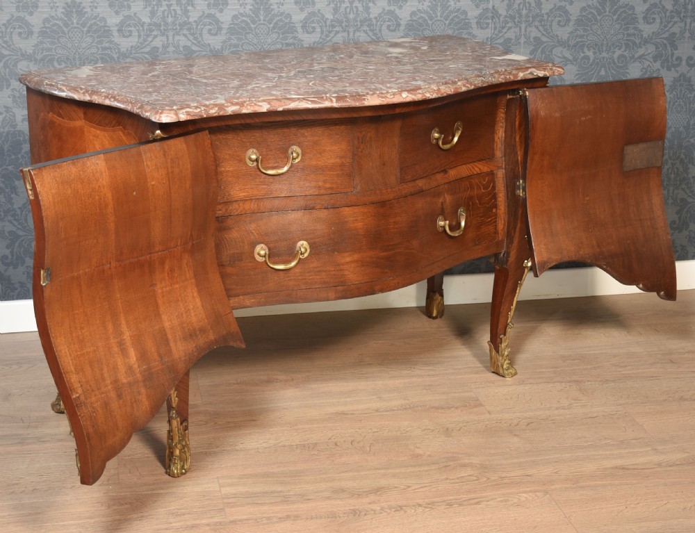 A late 18th-century French kingwood bombe commode featuring ornate gilt bronze mounts, cabriole legs, and a shaped marble top. View VIII