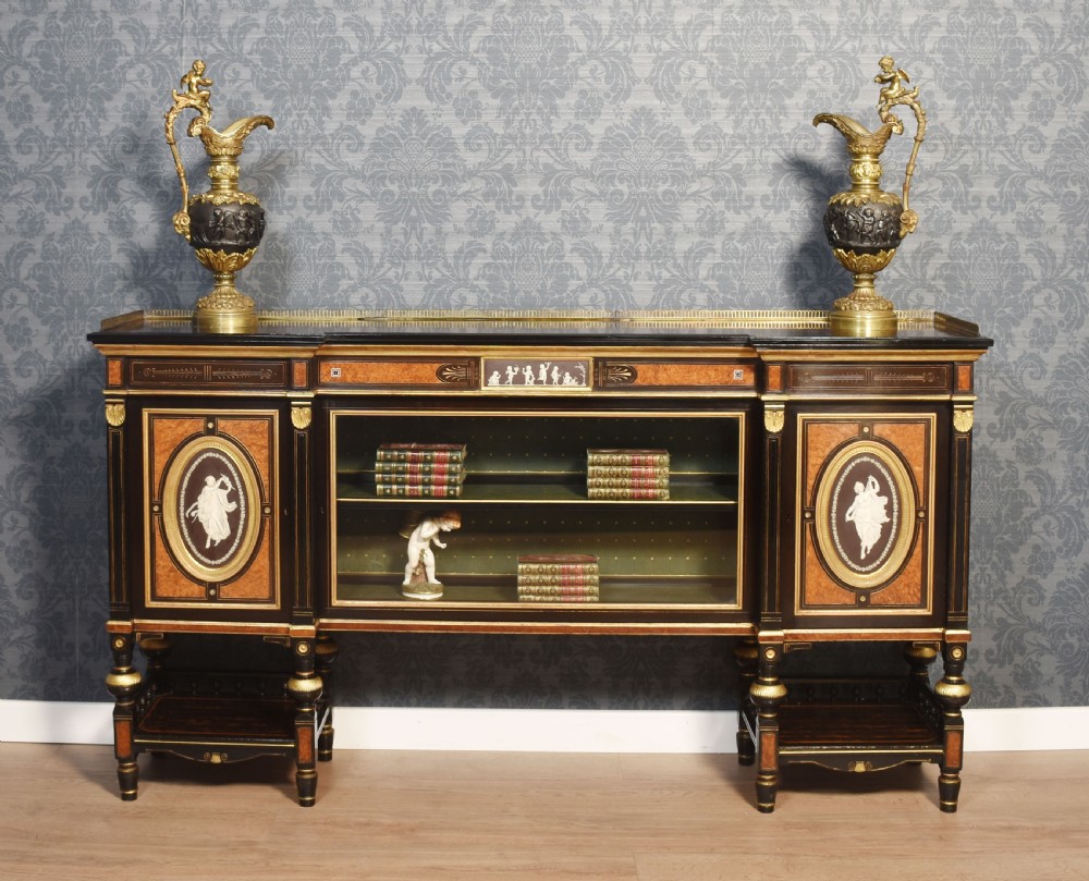A Victorian ebonised and coromandel side cabinet featuring central glazed shelves, side doors with oval classical cameo plaques, turned legs, and gilt brass details. View II