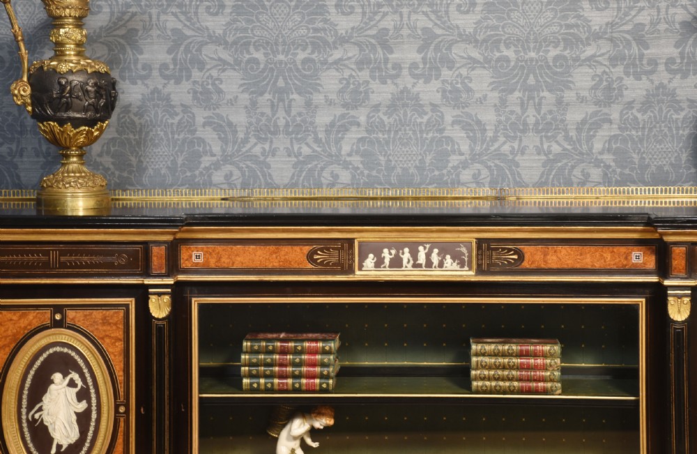 A Victorian ebonised and coromandel side cabinet featuring central glazed shelves, side doors with oval classical cameo plaques, turned legs, and gilt brass details. View III