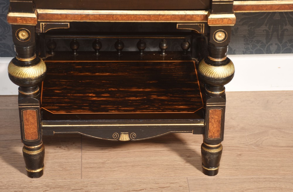 A Victorian ebonised and coromandel side cabinet featuring central glazed shelves, side doors with oval classical cameo plaques, turned legs, and gilt brass details. View XI