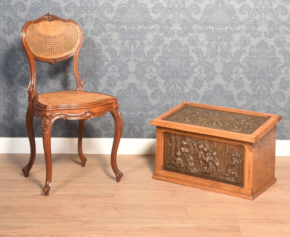 A Victorian slant-front oak slipper box featuring relief-embossed copper panels with cherubs on the front and a floral motif on the lid. View II
