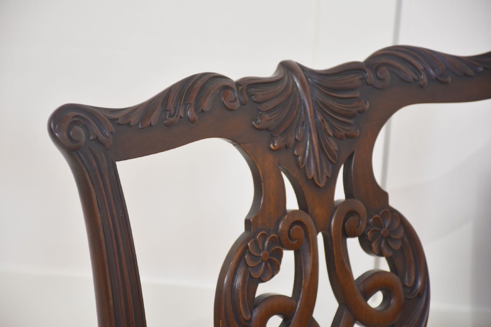 A set of eight mahogany Chippendale style dining chairs with carved splats, leather seats, and cabriole legs with ball-and-claw feet. View V