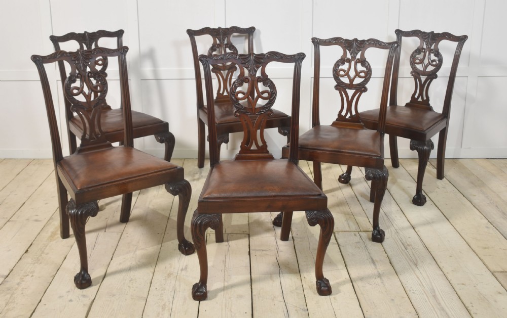 A set of eight mahogany Chippendale style dining chairs with carved splats, leather seats, and cabriole legs with ball-and-claw feet. View X