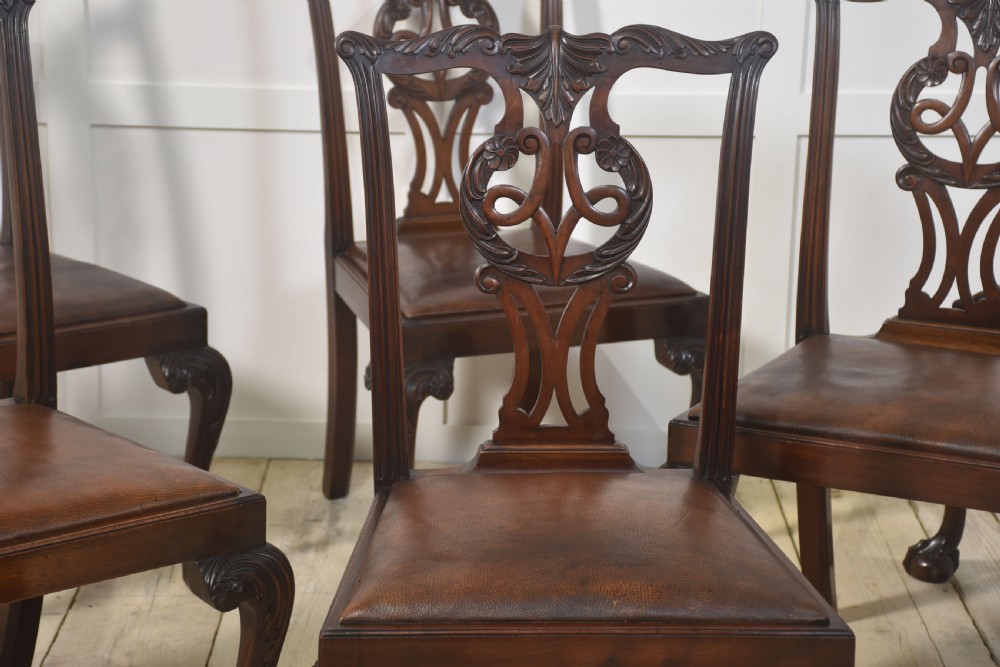 A set of eight mahogany Chippendale style dining chairs with carved splats, leather seats, and cabriole legs with ball-and-claw feet. View XI