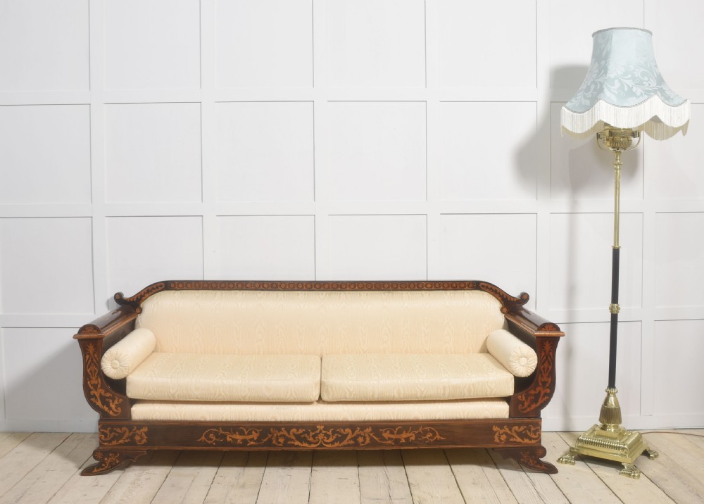 A Dutch marquetry settee with dark wood floral inlay along the frame and light cream upholstered cushions. View II