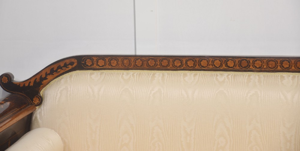 A Dutch marquetry settee with dark wood floral inlay along the frame and light cream upholstered cushions. View V