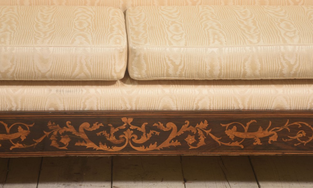 A Dutch marquetry settee with dark wood floral inlay along the frame and light cream upholstered cushions. View VIII