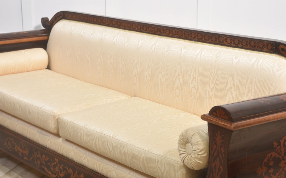 A Dutch marquetry settee with dark wood floral inlay along the frame and light cream upholstered cushions. View X
