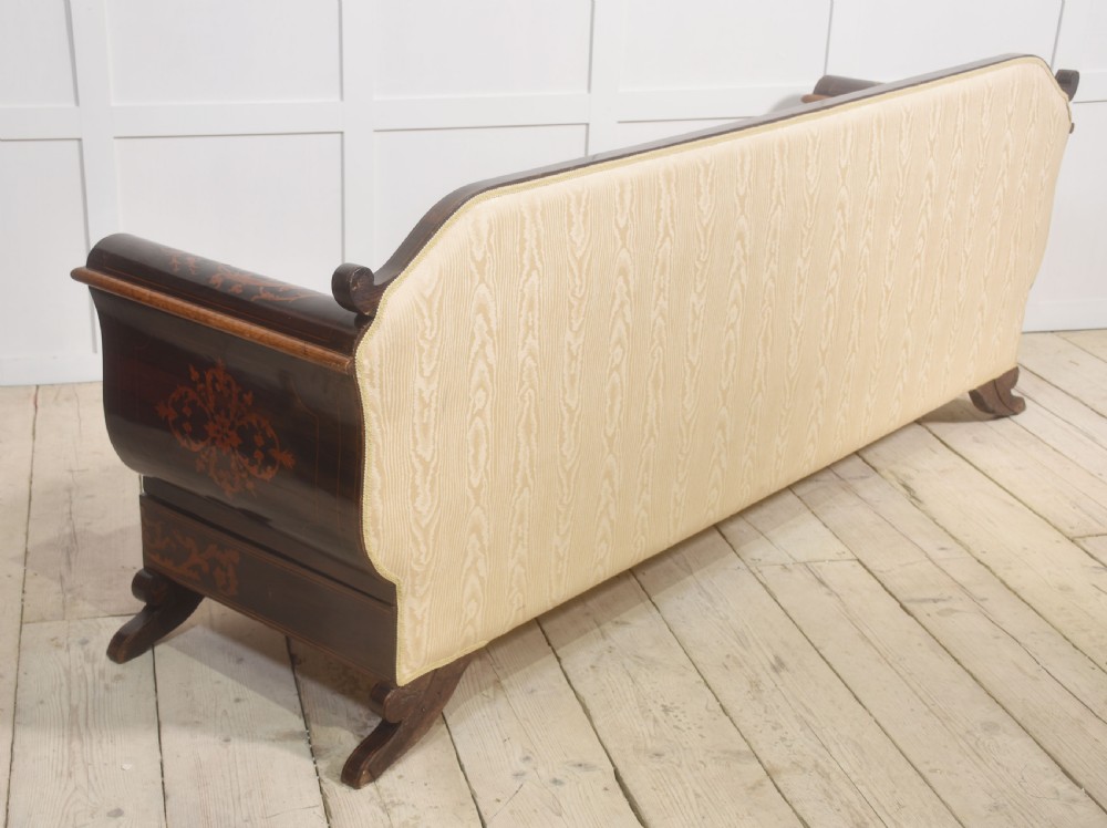 A Dutch marquetry settee with dark wood floral inlay along the frame and light cream upholstered cushions. View XIII