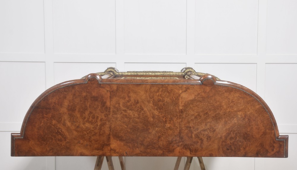 A Victorian burr walnut credenza featuring a central solid cupboard door with a porcelain plaque flanked by two bowed glazed side doors and gilt metal mounts. View XXI