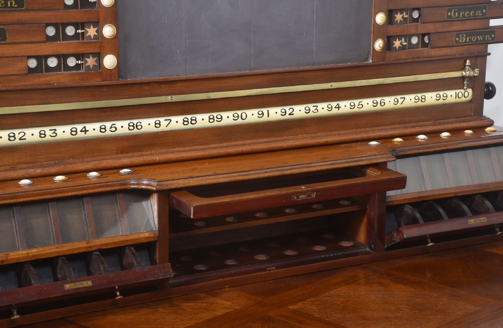 An antique Victorian mahogany billiard scoreboard featuring sliding colour pointers, a central slate panel, brass runners, and integrated ball compartments at the base. View XI