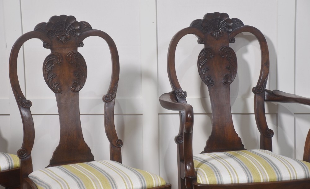 A set of eight carved dark walnut dining chairs with shell cresting rails, cabriole legs, ball-and-claw feet, and striped upholstered seat pads. View II