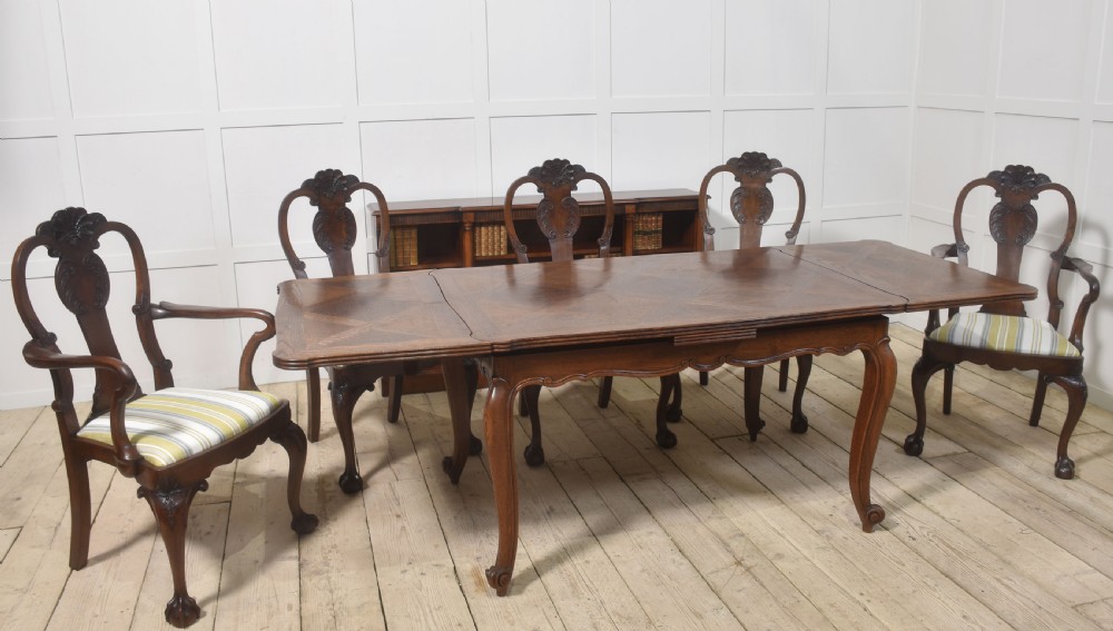 A set of eight carved dark walnut dining chairs with shell cresting rails, cabriole legs, ball-and-claw feet, and striped upholstered seat pads. View XI