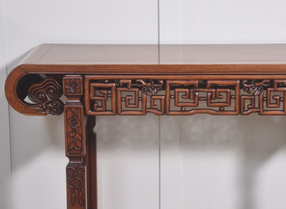 A Chinese carved hardwood altar table featuring upturned everted flanges, geometric openwork fretwork along the apron, and carved square legs. View II