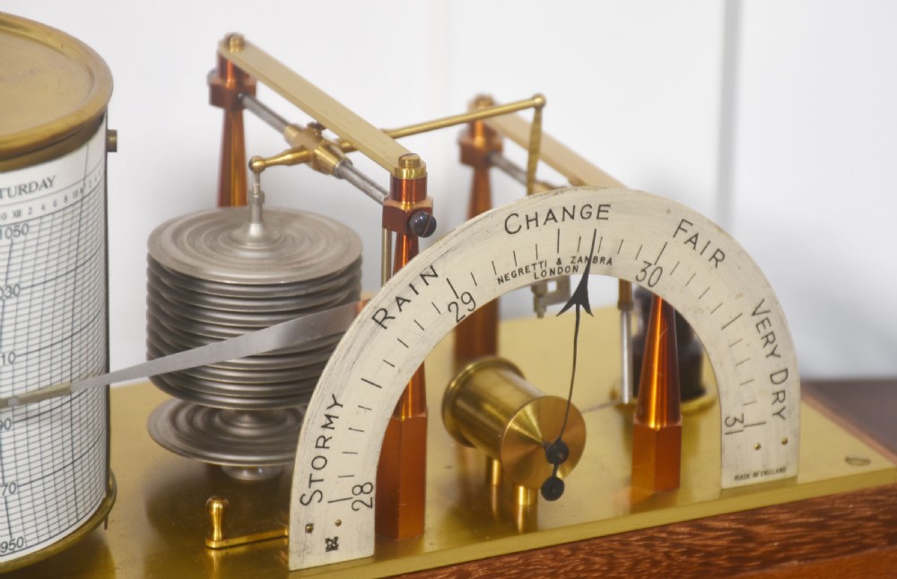 An antique mahogany-cased barograph with glass panels showing a revolving chart drum, brass mechanism, and silvered weather indicator arc. View III