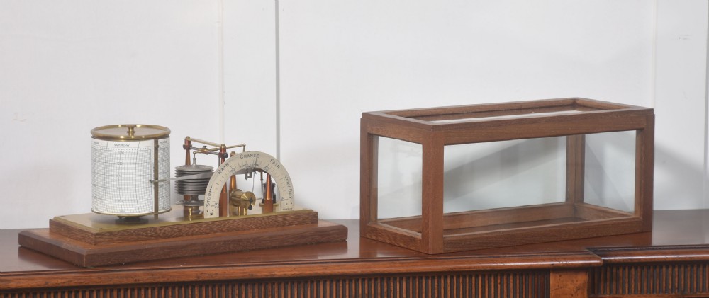 An antique mahogany-cased barograph with glass panels showing a revolving chart drum, brass mechanism, and silvered weather indicator arc. View VI