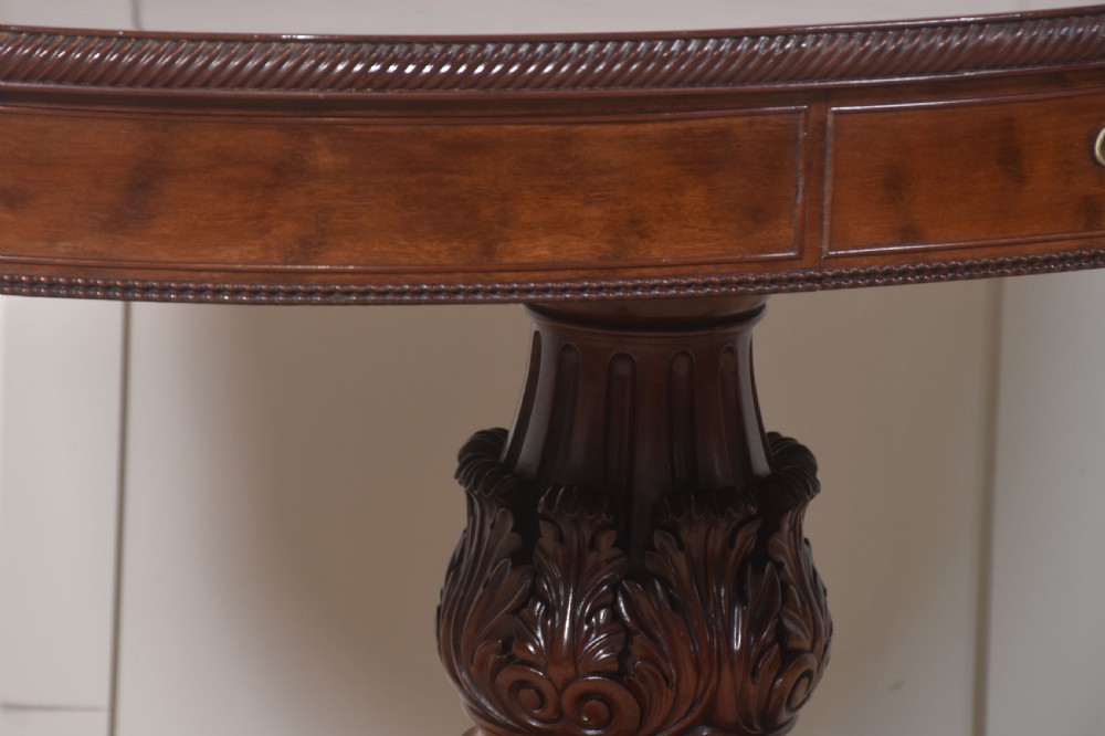 A 19th-century oval mahogany drum table featuring a reeded top edge, frieze drawers, and an elaborately carved acanthus pedestal on scroll legs with brass castors. View III