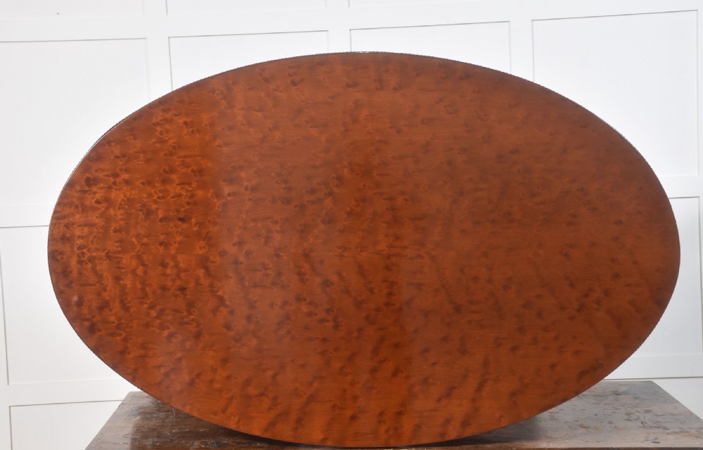 A 19th-century oval mahogany drum table featuring a reeded top edge, frieze drawers, and an elaborately carved acanthus pedestal on scroll legs with brass castors. View XIII