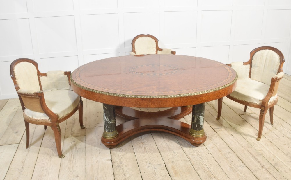An oval centre table featuring a burr walnut marquetry top, brass rim moulding, four green marble column supports, and a curved stretcher base. View II