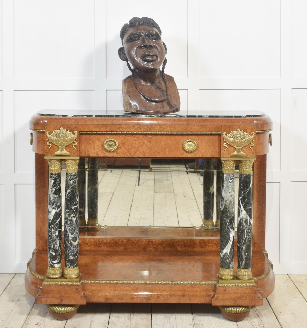 A French style console table with a dark marble top, burr timber veneer, polished marble column supports, gilt bronze mounts, and a mirrored backplate. View XII