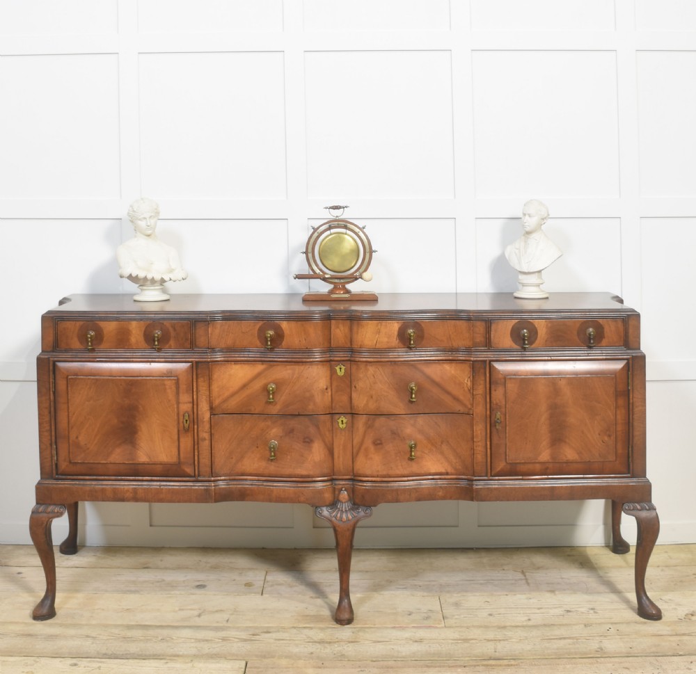 A wide walnut crossbanded Queen Anne style sideboard featuring multiple drawers, cupboard doors, drop brass handles, and carved cabriole legs. View II