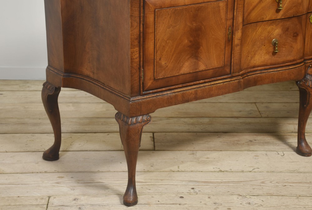 A wide walnut crossbanded Queen Anne style sideboard featuring multiple drawers, cupboard doors, drop brass handles, and carved cabriole legs. View III