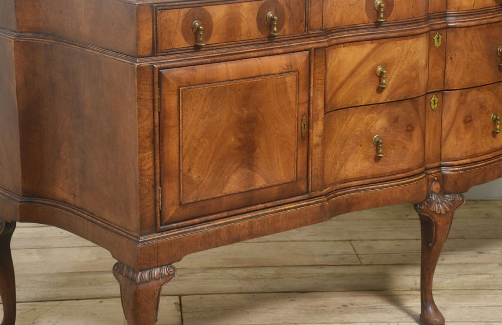A wide walnut crossbanded Queen Anne style sideboard featuring multiple drawers, cupboard doors, drop brass handles, and carved cabriole legs. View V