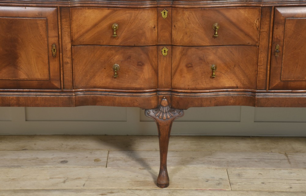A wide walnut crossbanded Queen Anne style sideboard featuring multiple drawers, cupboard doors, drop brass handles, and carved cabriole legs. View VIII