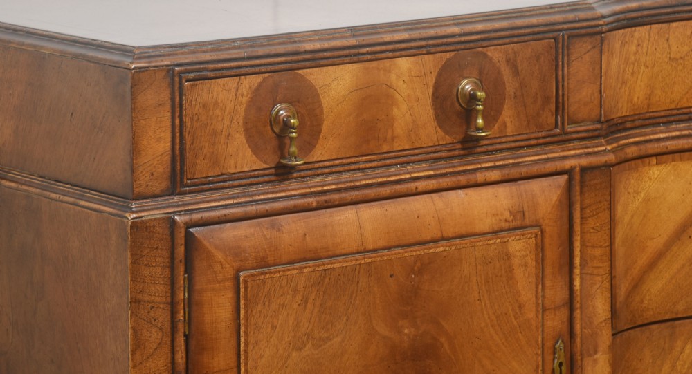 A wide walnut crossbanded Queen Anne style sideboard featuring multiple drawers, cupboard doors, drop brass handles, and carved cabriole legs. View IX