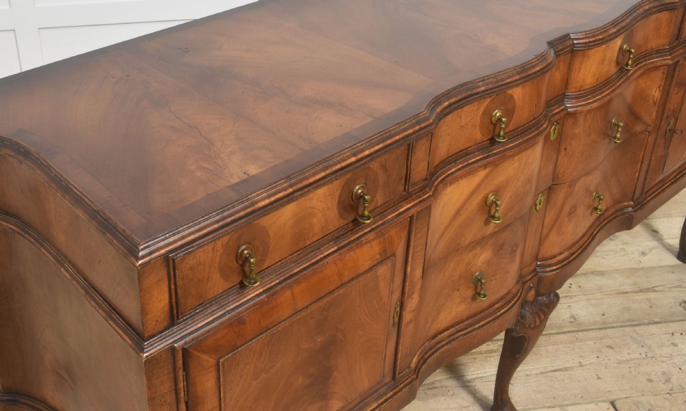 A wide walnut crossbanded Queen Anne style sideboard featuring multiple drawers, cupboard doors, drop brass handles, and carved cabriole legs. View XI