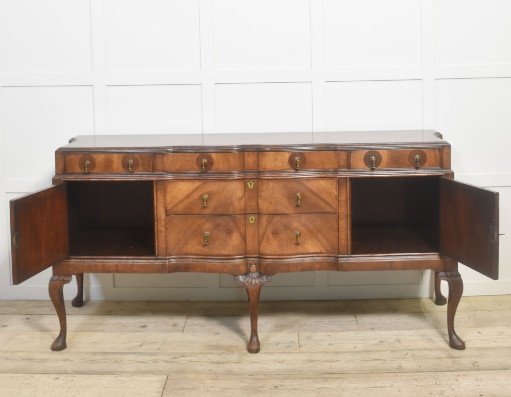 A wide walnut crossbanded Queen Anne style sideboard featuring multiple drawers, cupboard doors, drop brass handles, and carved cabriole legs. View XIII