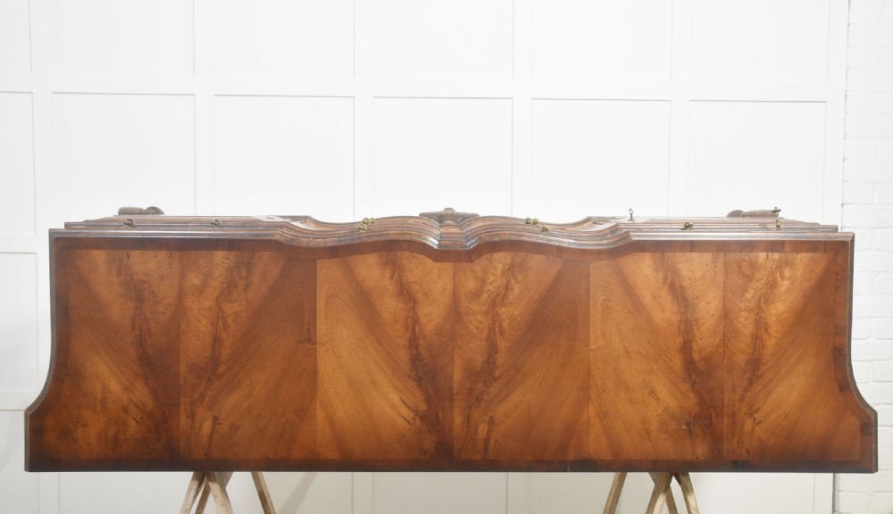 A wide walnut crossbanded Queen Anne style sideboard featuring multiple drawers, cupboard doors, drop brass handles, and carved cabriole legs. View XVII