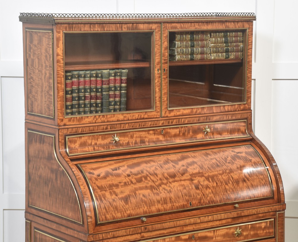 A pair of Georgian satinwood cylinder bureau cabinets with upper glazed doors, roll-top writing sections, and square tapered legs. View VI