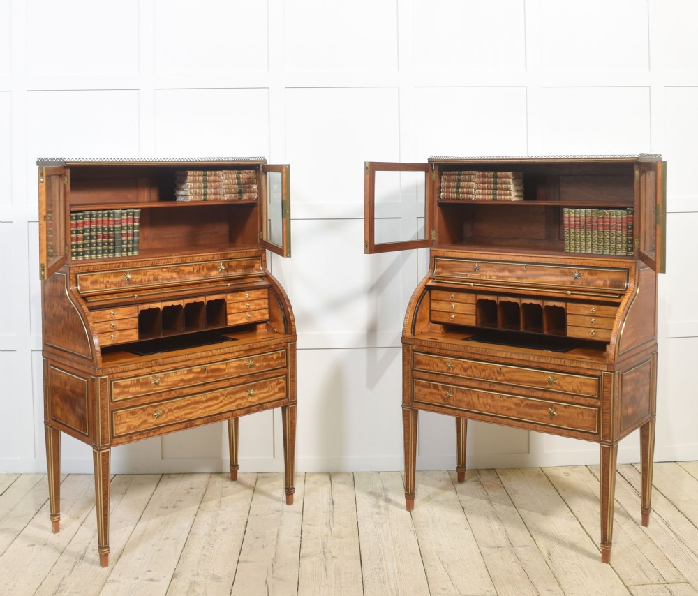 A pair of Georgian satinwood cylinder bureau cabinets with upper glazed doors, roll-top writing sections, and square tapered legs. View XVI