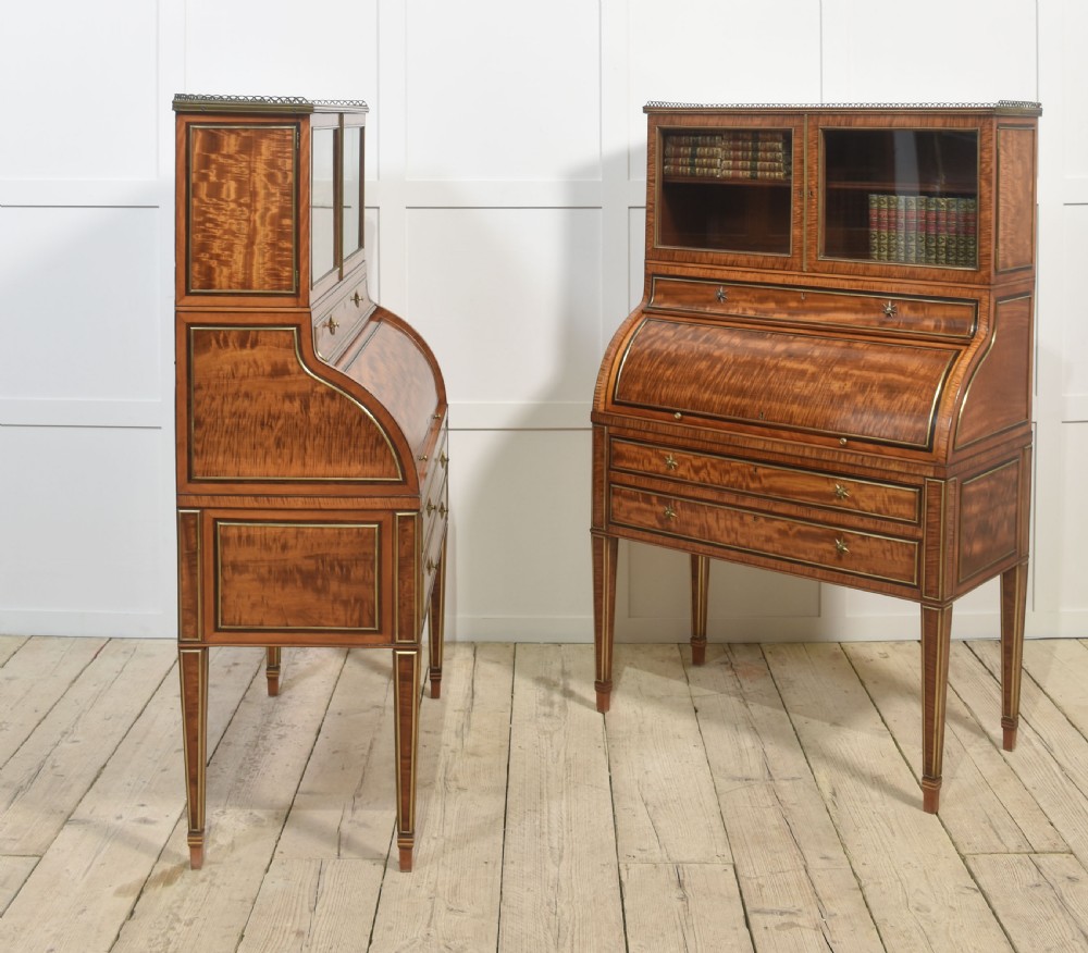 A pair of Georgian satinwood cylinder bureau cabinets with upper glazed doors, roll-top writing sections, and square tapered legs. View XX