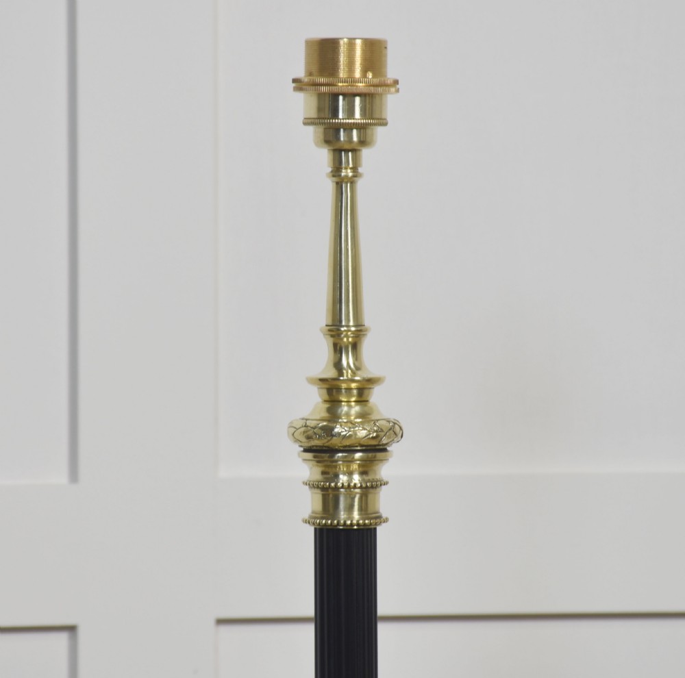 A Neoclassical brass and black standard lamp with an ornate tripod base, classical garland decorations, and a cream pleated fabric shade. View XII