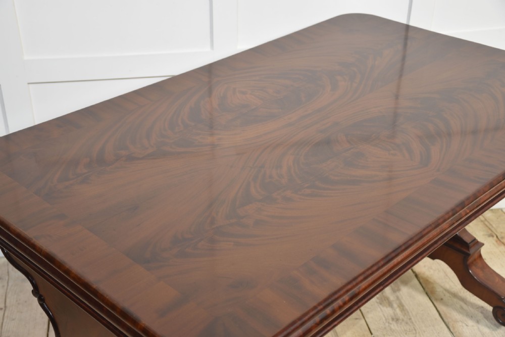A Victorian mahogany centre table featuring a polished rectangular top with rounded corners, trestle end supports, a spiral-turned stretcher, and scroll feet on castors. View VI