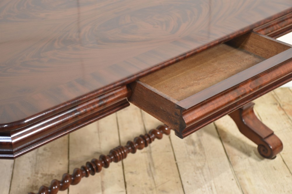 A Victorian mahogany centre table featuring a polished rectangular top with rounded corners, trestle end supports, a spiral-turned stretcher, and scroll feet on castors. View VII