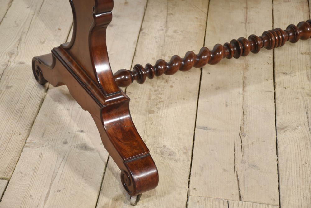 A Victorian mahogany centre table featuring a polished rectangular top with rounded corners, trestle end supports, a spiral-turned stretcher, and scroll feet on castors. View IX