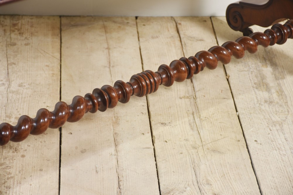 A Victorian mahogany centre table featuring a polished rectangular top with rounded corners, trestle end supports, a spiral-turned stretcher, and scroll feet on castors. View X