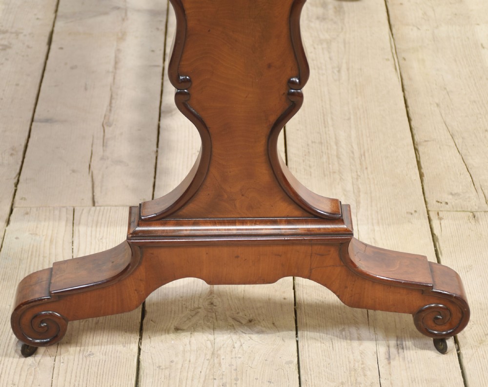 A Victorian mahogany centre table featuring a polished rectangular top with rounded corners, trestle end supports, a spiral-turned stretcher, and scroll feet on castors. View XII