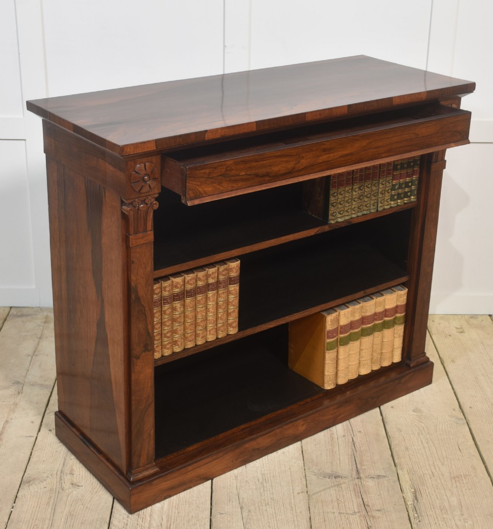 A 19th-century rosewood open bookcase featuring three open shelves, carved corner rosettes, pilasters, and a solid plinth base. View IX