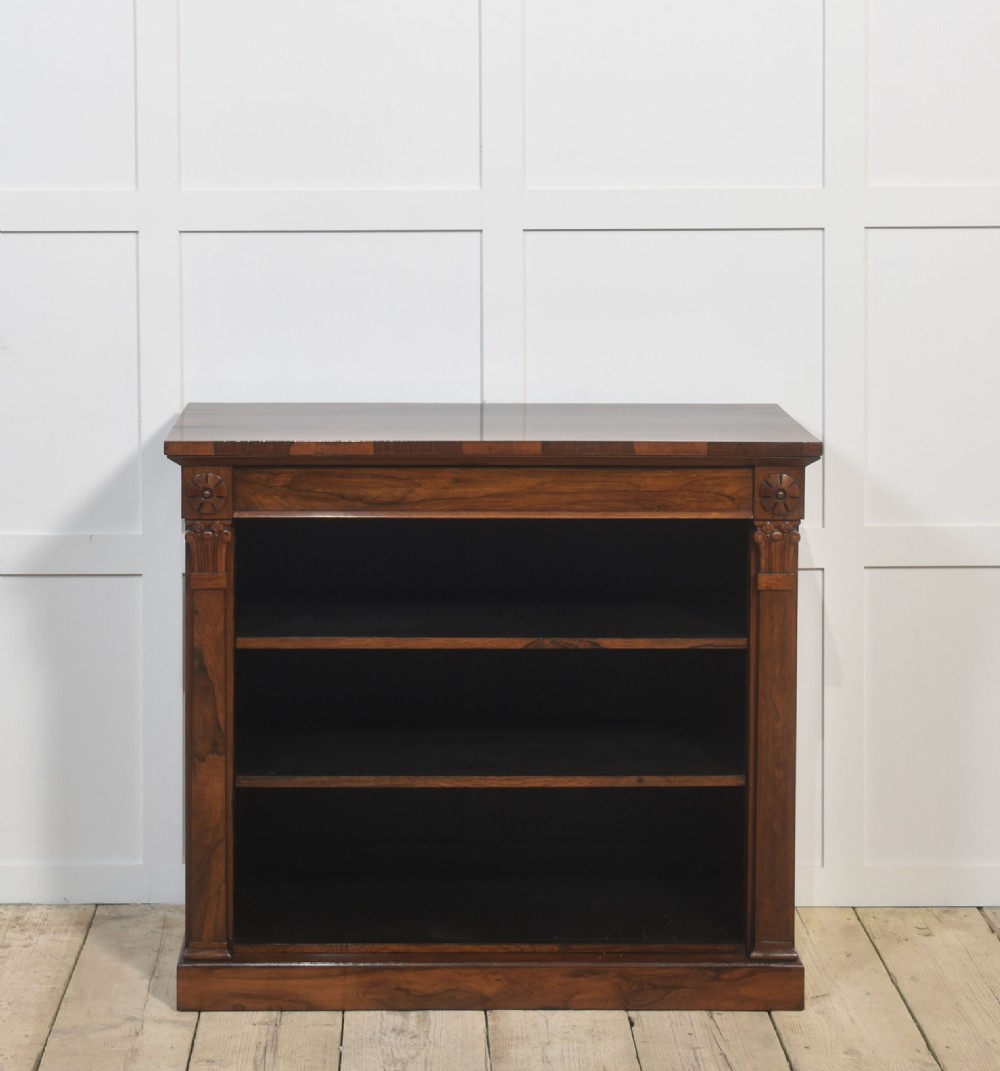 A 19th-century rosewood open bookcase featuring three open shelves, carved corner rosettes, pilasters, and a solid plinth base. View X