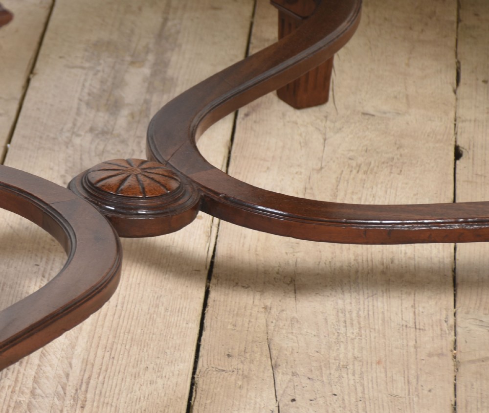 A walnut parquetry draw-leaf dining table featuring a geometric diamond-pattern top, fluted tapered legs, and a curved stretcher base. View V