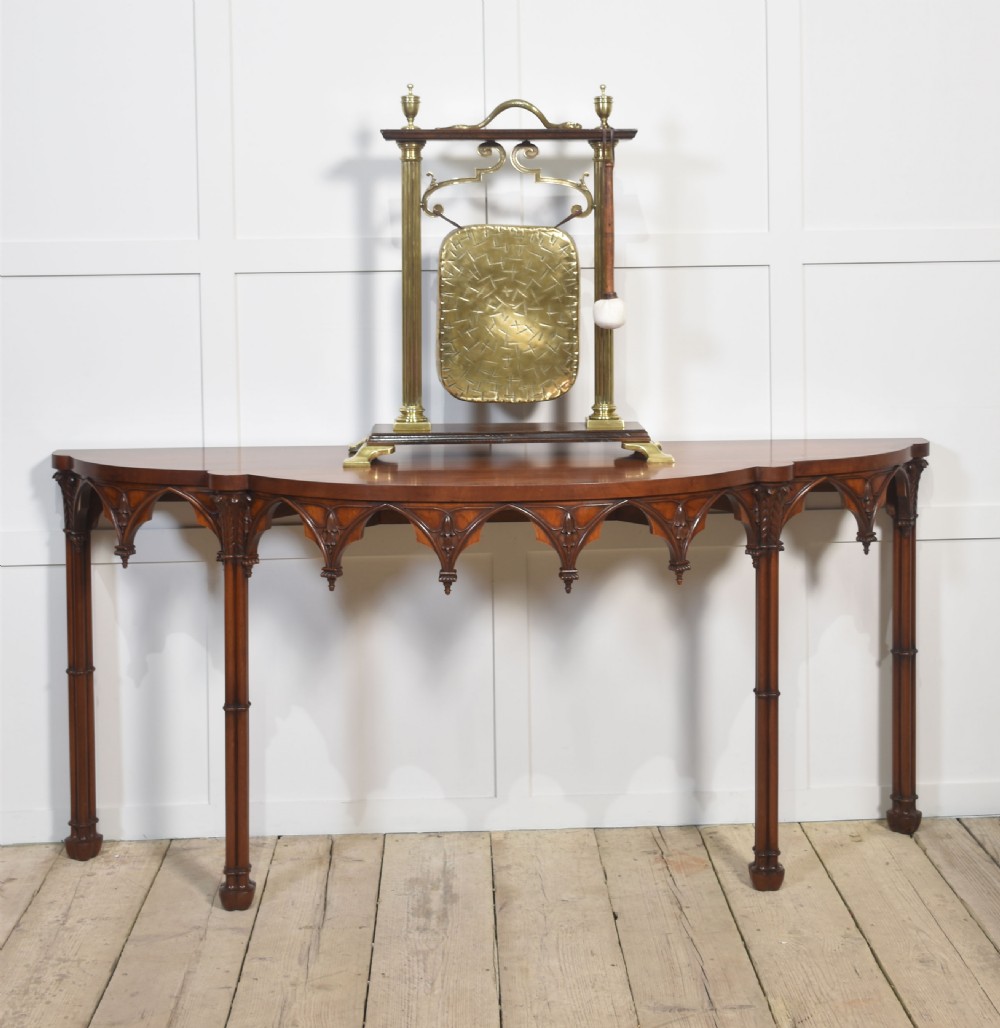 An antique brass table gong suspended within an oak frame with fluted brass columns, a serpent motif top handle, and a suspended mallet. View V