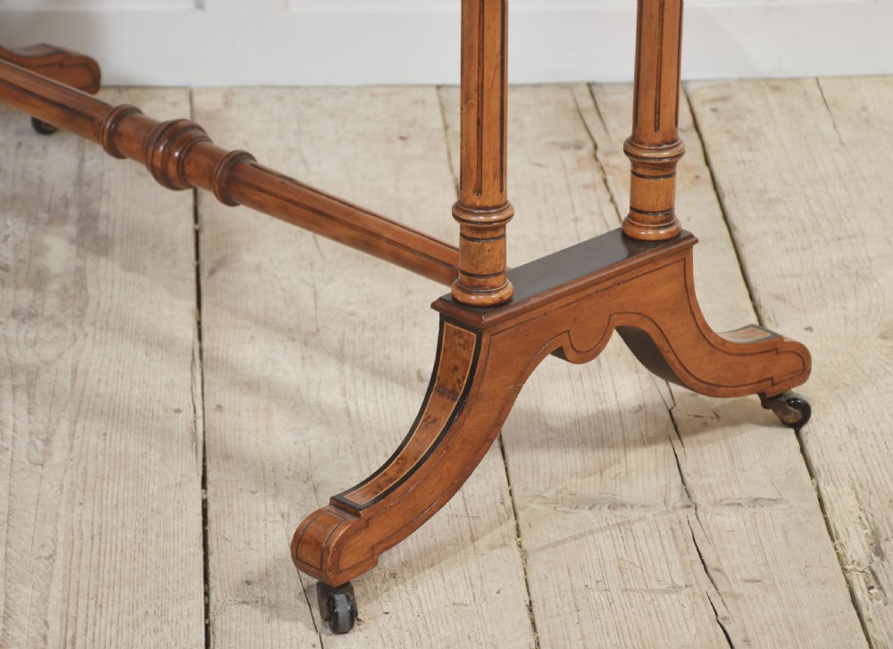 A Victorian burr walnut writing table featuring a green leather inset top with gold tooling, a single drawer, turned legs, a central stretcher, and brass castors. View IX