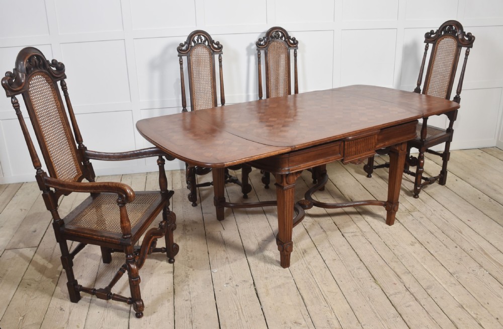 Set of eight carved dark oak high-back dining chairs with woven cane backrests and seats, comprising two armchairs and six side chairs. View II